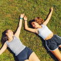 Dos chicas tiradas sobre la hierba